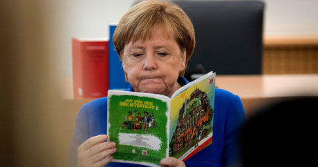 Меркель снова сидя слушала гимн