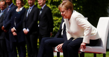 Меркель сидя слушала гимны перед переговорами в Китае